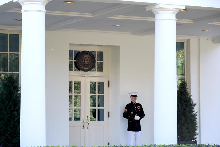 A U.S. Marine stands watch Wednesday outside the doors of the White House West Wing. According to the White House, President Trump was in the Oval Office on Wednesday afternoon, even as he continues to be monitored for COVID-19.