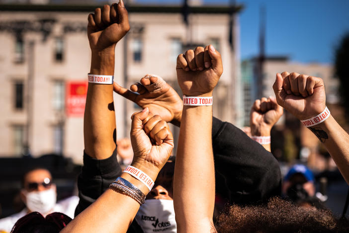 Black Lives Matter protesters display wristbands reading "I Voted" after leaving a polling place this month in Louisville, Ky. Activists warn Black and Latino voters are being flooded with disinformation intended to suppress turnout in the election's final days.