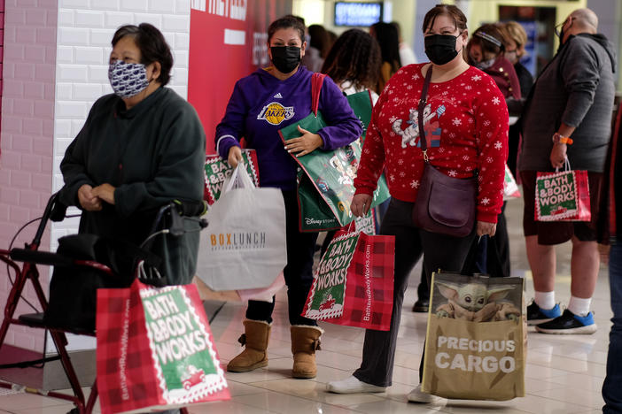 Black Friday shoppers wearing face masks wait in line to enter a store at the Glendale Galleria in Glendale, Calif., on Friday.