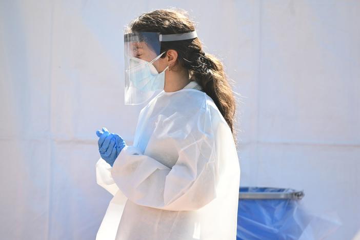 A health care worker is seen at a walk-up coronavirus testing site this week in San Fernando, Calif.