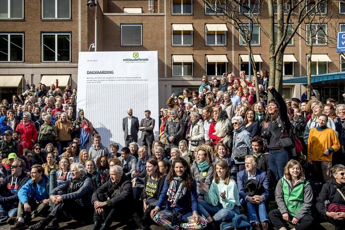 Activists march to Shell's headquarters in The Hague, Netherlands, in April 2019, delivering a legal summons to the company. The civil case began Tuesday, with plaintiffs demanding the company reduce its carbon dioxide emissions.