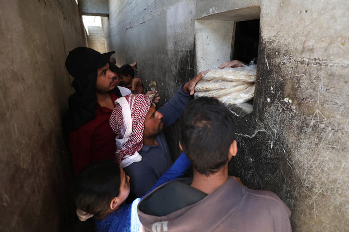 Syrians buy bread at a shop in the town of Binnish in the country's northwestern Idlib province in June. Nowadays, people say they're waiting up to six hours in line for a meager government bread ration.