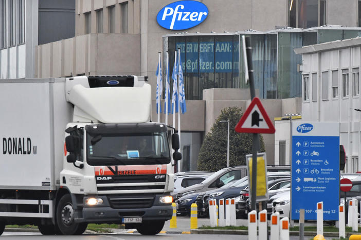 The U.K. will begin a mass vaccination against COVID-19 on Tuesday, as hundreds of thousands of doses of Pfizer's vaccine reach the public. Here, a temperature-controlled cold storage truck leaves a Pfizer facility in Belgium Thursday.