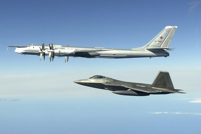 In this image taken June 16, 2020, and released by the North American Aerospace Defense Command, a Russian Tu-95 bomber (top) is intercepted by a U.S. F-22 Raptor fighter off the coast of Alaska. Russian nuclear-capable strategic bombers have flown near Alaska on a mission demonstrating the military's long-range strike capability.