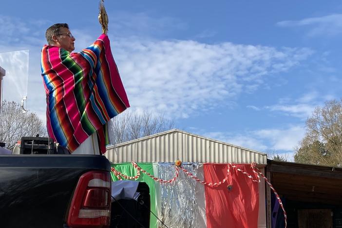 Father Julio Martinez raises the Blessed Sacrament from the back of a pickup truck in Ramseur, N.C.