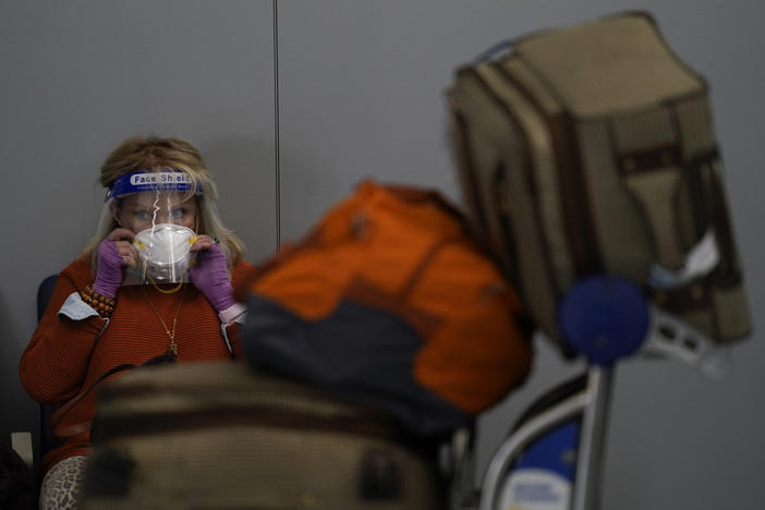 A traveler adjusts her mask while waiting to check in for her flight at the Los Angeles International Airport on Nov. 23.