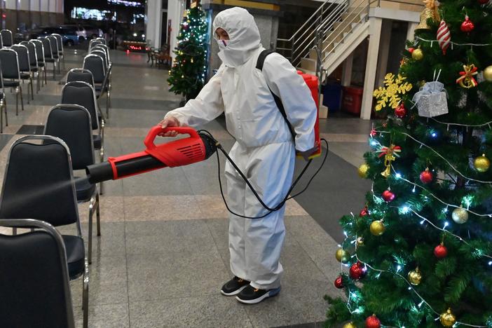 A worker wearing personal protective equipment disinfects the Holy Redeemer Church in Bangkok after a Christmas Eve mass. Thailand is one of many countries now seeing a surge in cases.