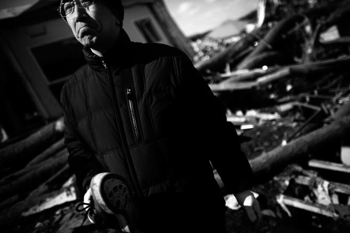 Jun Oshita, 46, holds a single shoe, the only memory he could find of his mother. Kuni Oshita, 73, was killed in the March 11 tsunami in Noda, which was almost completely destroyed after the earthquake and tsunami.