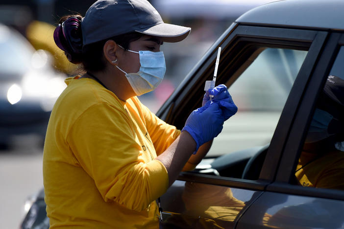 A worker prepares to give a COVID-19 vaccine last week at the Dignity Health Sports Park in Carson, Calif.