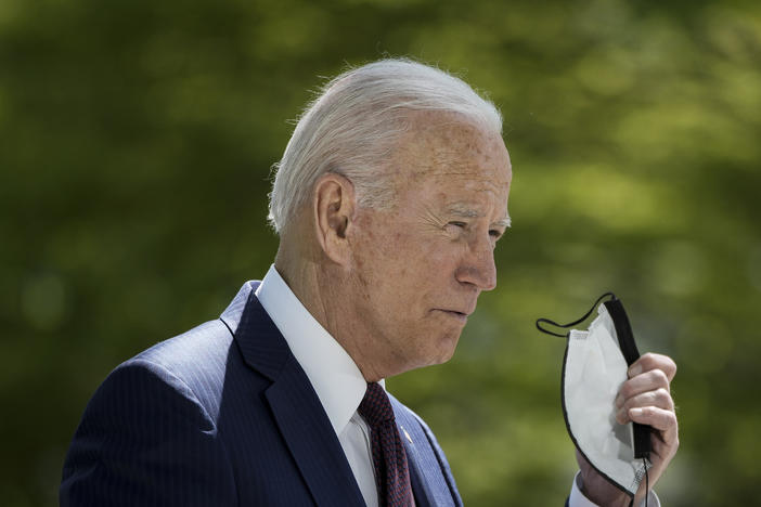 President Biden removes his mask before speaking about the pandemic Tuesday afternoon outside the White House.