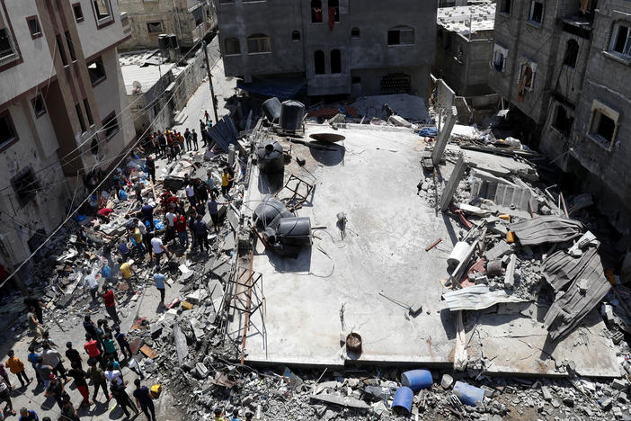People gather near the rubble of a residential building hit by Israeli airstrikes Thursday in Beit Lahiya, Gaza Strip.