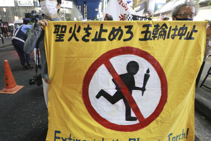 People carry a banner reading "Extinguish the Olympic torch" during a march in Tokyo last week calling for the cancellation of the Summer Olympics. The government insists the games will go on despite concerns about the coronavirus.