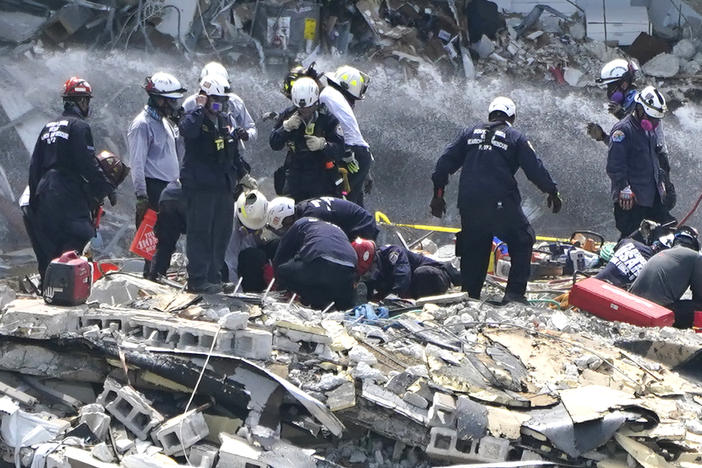 Rescue workers search the rubble of the Champlain Towers South condominium on Saturday in the Surfside area of Miami. The building partially collapsed on Thursday.