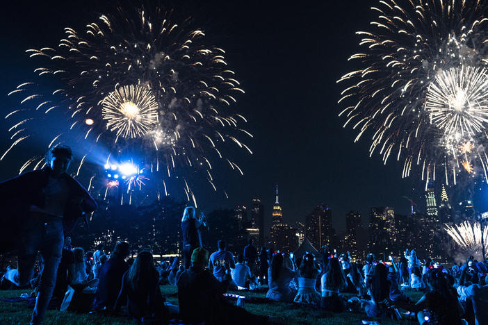 Spectators watch from a Queens neighborhood as fireworks are launched over the East River and the Empire State Building during the Macy's 4th of July Fireworks show in New York.
