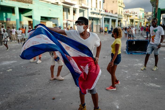 A man waves a Cuban flag during a demonstration against Cuban President Miguel Díaz-Canel's government Sunday in Havana as large numbers take part in rare protests against the communist regime.
