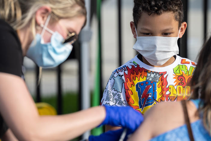 A child watches as a nurse administers a COVID-19 vaccine during a pop-up vaccination event in April at Lynn Family Stadium in Louisville, Ky.