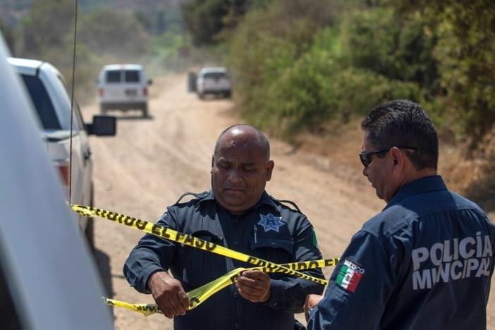 Officers hold a police cordon at the scene where two young American children were found dead in Rosarito in the Mexican state of Baja California on Monday.
