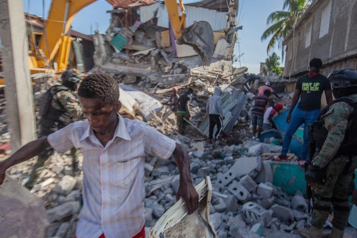 Haitians in Les Cayes assess the damage Sunday after a magnitude 7.2 earthquake struck a day earlier.