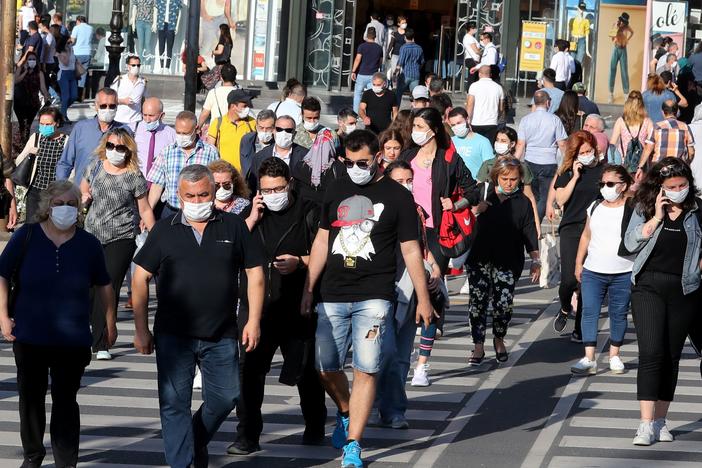 People don face masks to help keep the coronavirus at bay in June in Ankara, Turkey. But what about earlier recommendations to stay 6 feet away from others and limit close contact to 15 minutes? Are these still effective against the contagious delta variant?