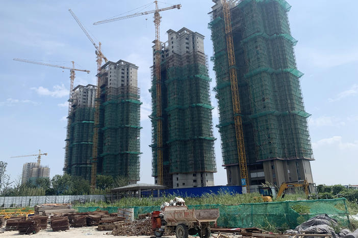 Half-finished apartment towers are part of Evergrande's Cultural City real estate project in Taicang, China. The firm has run out of money to finish the buildings as regulators force developers to pay back debts.