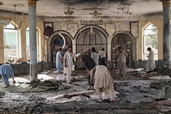 People sift through the damage inside of a mosque following a bombing in Kunduz province northern Afghanistan on Friday.