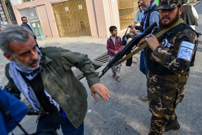 A member of the Taliban special forces pushes a journalist covering a demonstration by women protesters in Kabul on Sept. 30.
