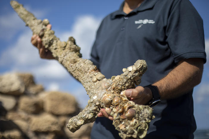Jacob Sharvit, director of the Marine Archaeology Unit of the Israel Antiquities Authority, holds a sword that experts say dates back to the Crusaders in Cesarea, Israel, on Tuesday.