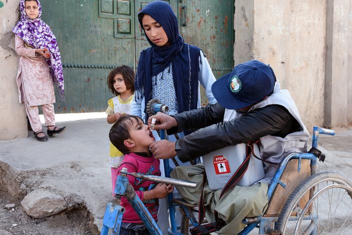 An Afghan health worker administers a polio vaccine to a child in Kandahar province in 2019. Since 2018, the Taliban has blocked polio vaccination campaigns in parts of the country it controls. Now they're reportedly changed their position.
