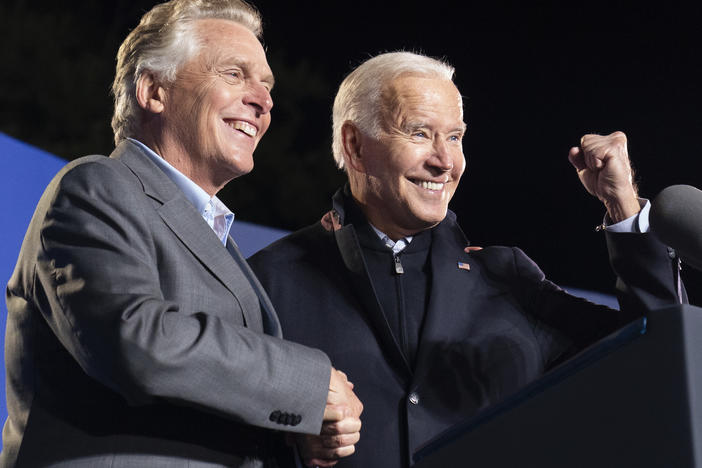 President Biden, right, reacts after speaking at a rally for Democratic gubernatorial candidate and former Virginia Gov. Terry McAuliffe on Tuesday in Arlington, Va. McAuliffe will face Republican Glenn Youngkin in the election on Nov. 2.