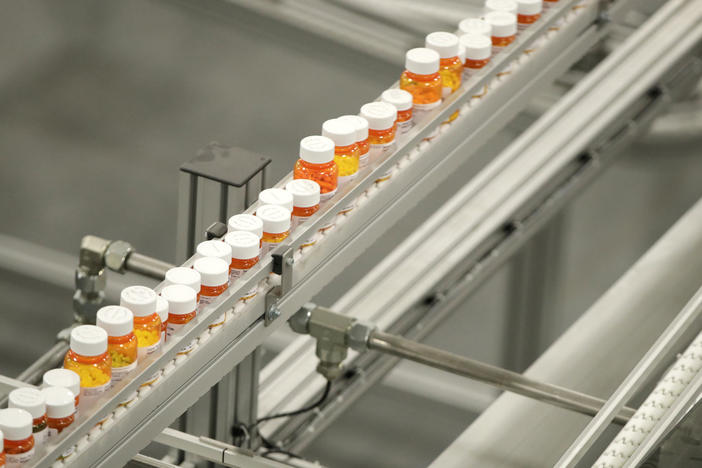 Bottles of medicine ride on a belt at the Express Scripts mail-in pharmacy warehouse in Florence, N.J., in 2018. Democratic lawmakers have reached a deal to lower prescription drug prices for seniors.