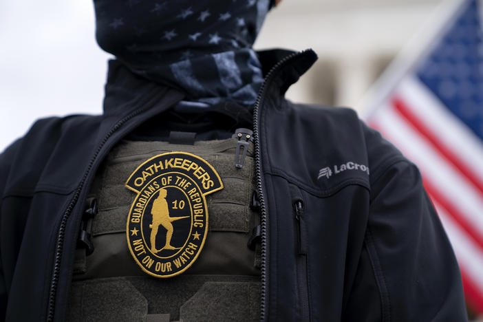 A demonstrator wears a badge for the extremist group the Oath Keepers on a protective vest during a protest outside the Supreme Court in Washington, D.C., the day before the Capitol siege.