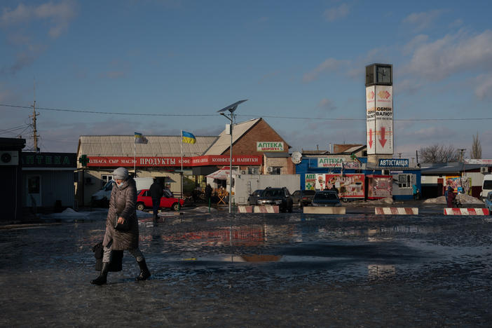 A woman walks towards the only crossing right now between the rest of Ukraine and the northernmost occupied territory, manned by guards on both sides who check documents in Stanytsia Luhanska.