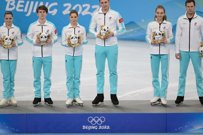 Members of the Russian Olympic Committee team celebrate at the flower ceremony after the figure skating team event. The team won gold in the event, but the medal ceremony has been delayed for unspecified legal reasons.