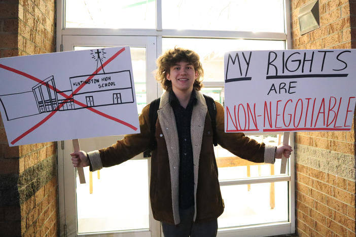 Huntington High School senior Max Nibert holds signs he plans to use during a student walkout at the school in Huntington, W.Va., on Feb. 9. Now, families are suing the school district, alleging it violated students' religious freedoms.