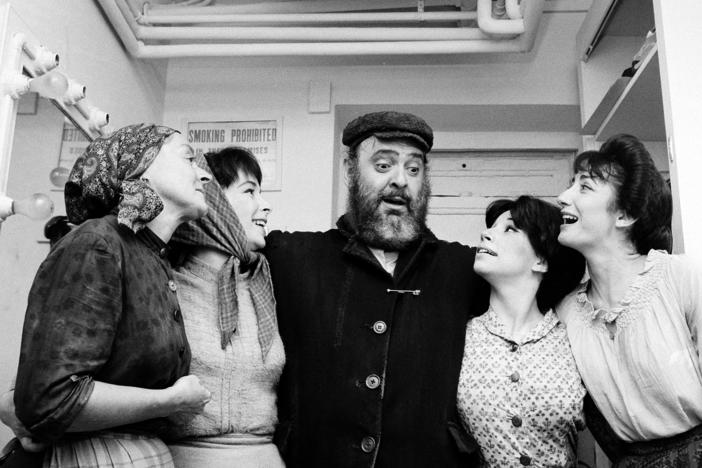 Actor Zero Mostel, center, who portrays Tevye in the musical "Fiddler on the Roof," poses backstage with cast members after the play's opening performance at the Imperial Theatre in New York on Sept. 22, 1964. Maria Karnilova, who plays Tevye's wife, Golde, is at far left. Playing Tevye's daughters, from left, are, Tanya Everett, as Chava; Julia Migenes, as Hodel; and Joanna Merlin, as Tzeitel.