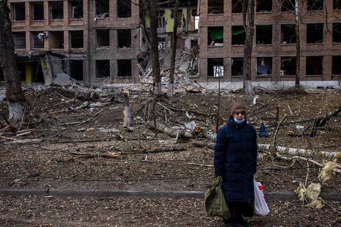 A woman stands in front of a destroyed building after a Russian missile attack in the town of Vasylkiv, near Kyiv, on  Sunday. Russian forces faced stiff resistance over the weekend and faced logistics problems in their invasion plans.