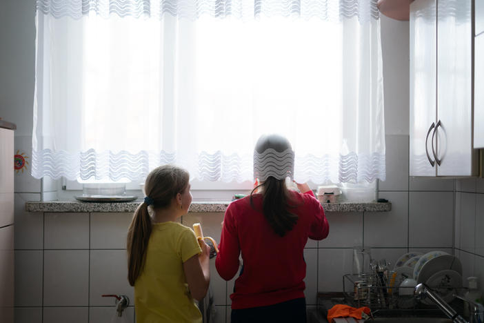Two Ukrainian girls in foster care look out the window of a home they are now sharing with a Polish foster family in Bilgoraj, Poland. More than 1.5 million Ukrainians — many of them children — have fled since the Russian invasion.