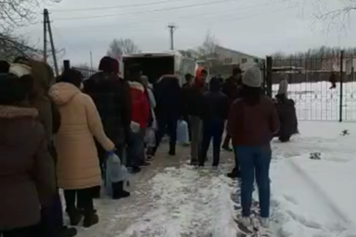 People line up to get water at Sumy State University in Ukraine. Many international students have been unable to leave the city of Sumy and are waiting for their embassies to help.