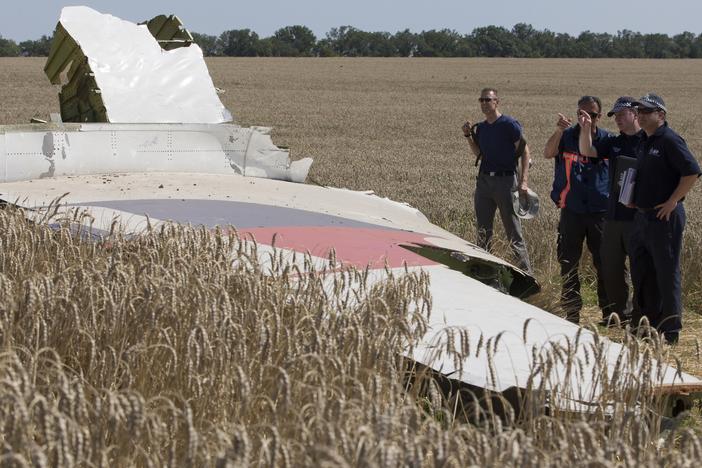 Australian and Dutch investigators examine a piece of the downed Malaysia Airlines Flight 17 plane, in eastern Ukraine's Donetsk region in August 2014.