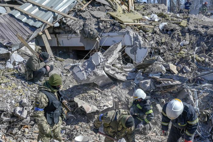 Ukrainian soldiers and rescue officers search for bodies in the debris at a military school in Mykolaiv on Saturday. Russian rockets hit the school the day before.