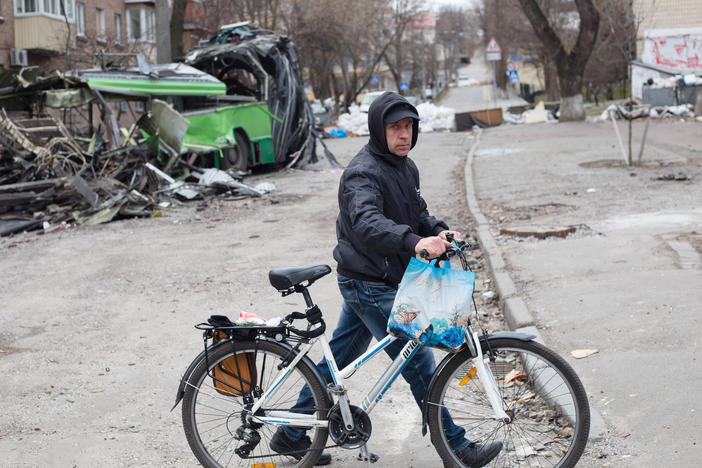 A man with a bicycle walks near a tram which got destroyed by a rocket strike in the area few weeks ago on Monday in Kyiv, Ukraine.