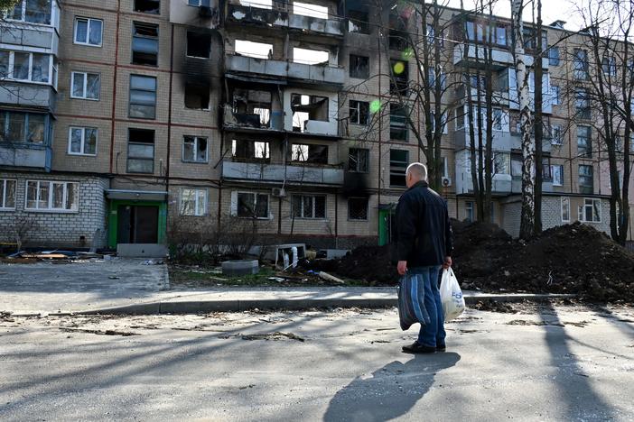 A man looks at a five-story residential buildings in the Ukrainian city of Kharkiv, on April 10, 2022.