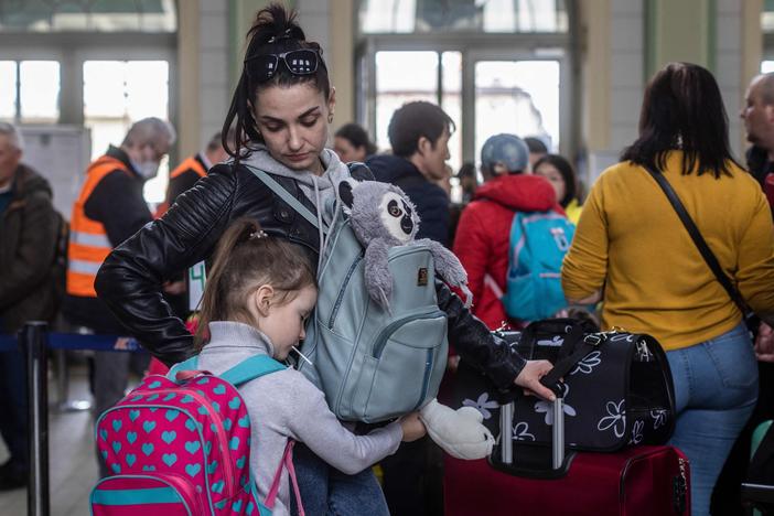 A woman and a child, along with other refugees from Ukraine, wait in the ticket hall of the railway station in Przemysl in eastern Poland.