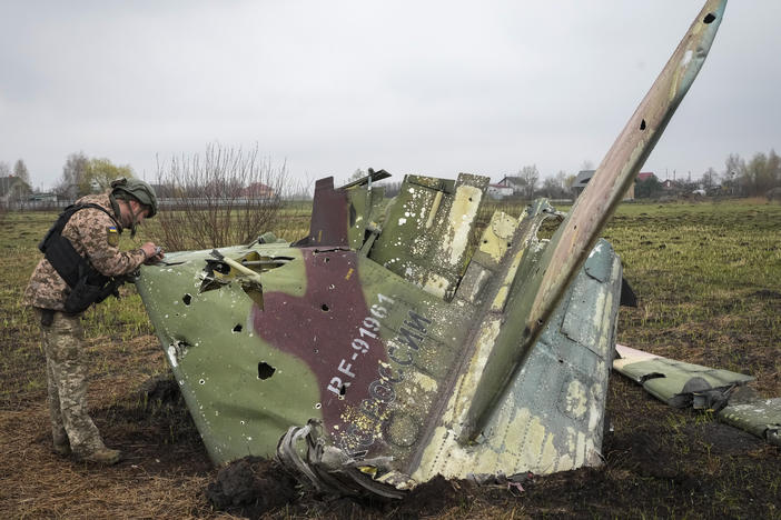 A Ukrainian soldier examines a fragment of a Russian Air Force Su-25 jet after a battle at the village of Kolonshchyna, Ukraine, on April 21. Russia was expected to establish air superiority in the first days of the war. But Ukraine's air defenses have been so effective that Russian pilots often fire their weapons while over Russia and never enter Ukrainian airspace.