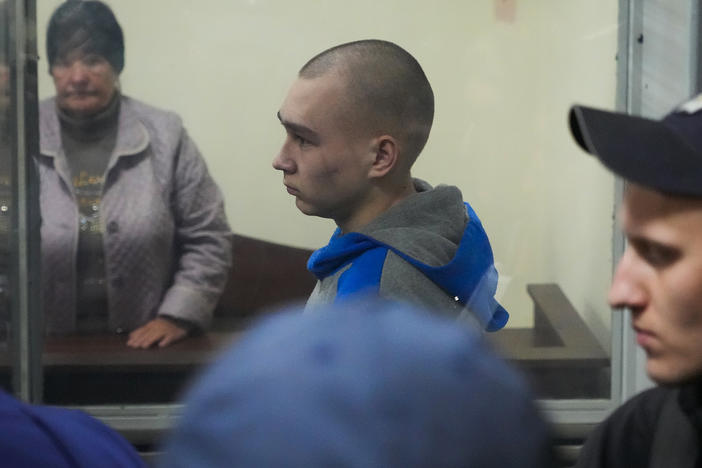 Russian army Sgt. Vadim Shishimarin, 21, is seen behind glass during a court hearing in Kyiv on Wednesday. He went on trial in Ukraine for the killing of an unarmed civilian and pleaded guilty. It is the first time a member of the Russian military has been prosecuted for a war crime since Russia invaded Ukraine in February.