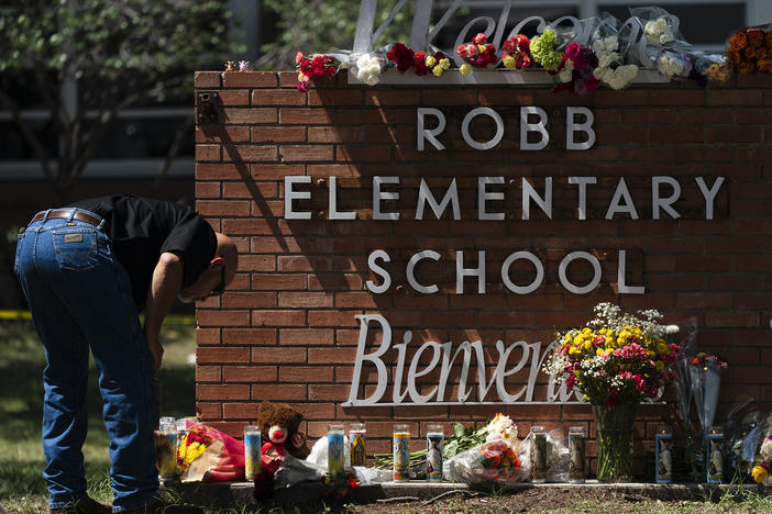 A law enforcement personnel lights a candle outside Robb Elementary School in Uvalde, Texas, Wednesday, May 25, 2022. Desperation turned to heart-wrenching sorrow for families of grade schoolers killed after an 18-year-old gunman barricaded himself in their Texas classroom and began shooting, killing several fourth-graders and their teachers.