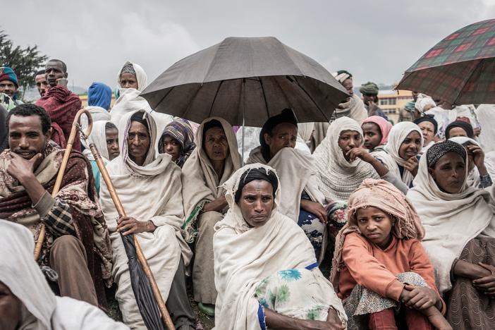 People who fled from fighting in Ethiopia gather in a temporary internally displaced people camp to receive first bags of wheat from the World Food Programme. Ethiopia saw a record 5.1 million displacements in 2021.