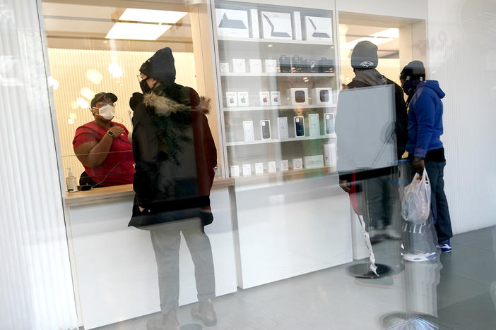 Customers pick up online orders at the Apple Store at the Towson Town Center in December 2020 in Towson, Md. Apple store employees in the Baltimore suburb voted to unionize by a nearly 2-to-1 margin on Saturday.