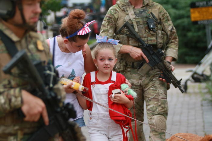 Law enforcement escorts a family away from the scene of a shooting at a parade on July 4 in Highland Park, Ill.