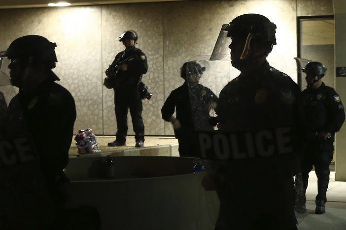 Phoenix police stand in front of police headquarters on May 30, 2020, in Phoenix, waiting for protesters marching to protest the death of George Floyd.